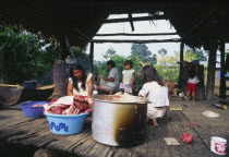 Machiguenga mother with family preparing food.