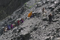 Group of travellers negotiating a land slide on the Karakorum Highway.