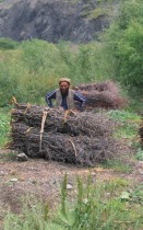 Hill dweller collecting wood.