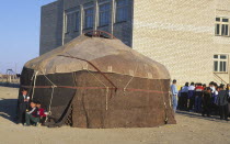 Yourt in Kazakh playground with groups of children nearby.yurt  yurta  a nomads tent made of felt.