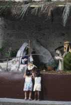 Two young girls admiring a nativity show.
