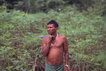 Tukano indian shaman  with machete and chewing coca.Vuapes