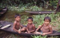 Three tukano Indian boys sat in canoe and empty canoe behind them. Vuapes