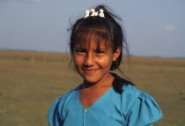 A young Llanera girl wearing a blue top and a hair clip with dogs on.