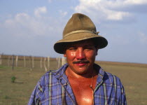 Llanero cowboy wearing a hat and standing in a field.