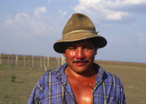 Llanero cowboy wearing a hat and standing in a field.