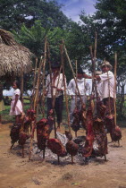 Carne a la llanera  A circle of meat on sticks round a fire with a few people standing next to it.