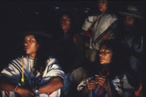 Ica family sat down and listening to Ica elder talking at night time.