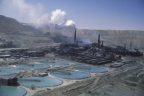 Copper Mine with smoke coming out of  stacks in the distance.