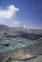 Copper Mine with smoke coming out of a stack in the distance.