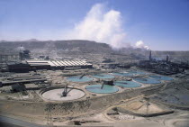 Copper Mine  smoke coming out of a stack in the distance. General industrial landscape.