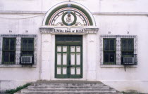 Front of the central bank with steps leading up to the front door and windows either side.