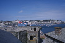 St Peter Port. View from Castle Cornet with Union Jack flying. Marina and quayside buildings in the distance.
