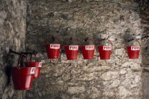 St Peter Port. Castle Cornet. Red fire sand buckets hanging from stone wall