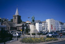 St Peter Port. Albert Prince Consort statue on weighbridge roundabout with the town church behind. The Albion House pub  restaurants  and shops lining the esplanade