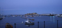 St Peter Port. Cornet Castle at dusk seen from across water.