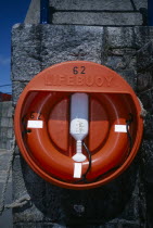 St Peter Port. Red Lifebuoy attached to sea wall.lifebeltliferingperry buoykisby ring