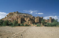 Kasbah famous for appearing in films such as Jesus of Nazareth and Lawrence of Arabia.  Exterior walls with small group of people in foreground.