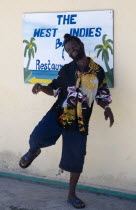 Man dancing beside a restaurant sign in Clifton