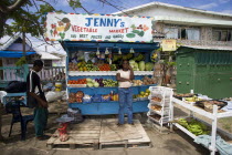 Fruit and vegetable market stall with owner in Hugh Mulzac Square in Clifton