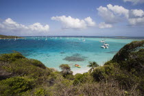View across the beach at Jamesby Island towards moored yachts