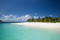 The beach at Palm Island Resort with guests sitting in the water