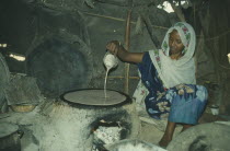 Woman cooking inside tent.