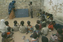 Teacher with pupils in outdoor classroom at school in Baidoa orphanage.