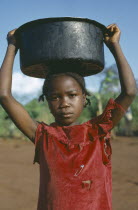 Young girl carrying water vessel on her head.Zaire Congo