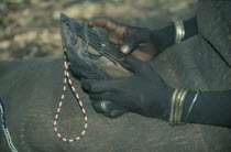 Cropped view of Mursi girl playing traditional thumb piano musical instrument.Pastoral tribe aka Murzu