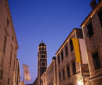 View along the Stradun toward the Francisan Monastery tower illuminated at dusk
