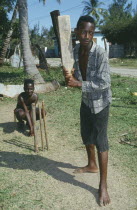 Two boys playing cricket