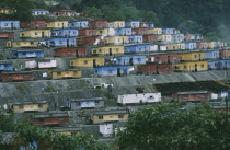 Red   yellow and blue painted housing built on a concreted hillside
