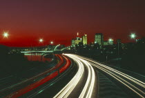 The south east freeway approaching the city illuminated at night with red and white traffic light trails.