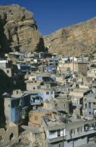 View over village set into eroded red stone cliff face.