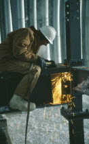 Man wearing protective hat and clothing  welding on a metal structure at the US Amundsen-Scott South Pole Station.
