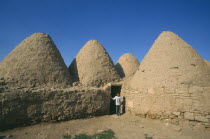 Beehive mud houses with boy standing at doorway