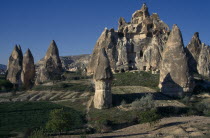 Cave houses carved into large rock surrounded by Fairy chimneys