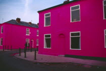 Terrace houses on Ash Street painted shocking pink with couple standing in the road