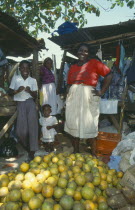 Fruit stall in the market with two female vendors and two children