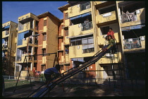 New housing estate with children playing on a slide in the foreground