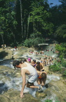 Tourists help each other up to the top of Dunns River Falls