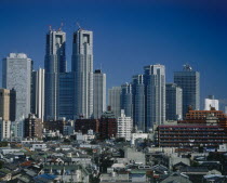 Shinjuku high-rise skyscrapers seen beyond the rooftops of the city