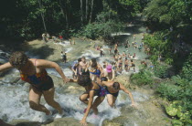 Tourists helping each other up to the top of Dunns River Falls