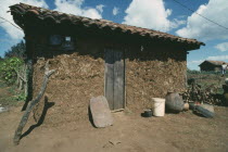Exterior of a Chamula Indians house with mud walls and tiled roof