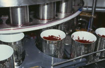 Cans without lids being filled in processing plant