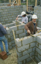 Workmen laying concrete blocks