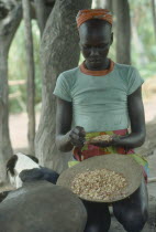 Dinka tribeswoman shelling groundnuts.
