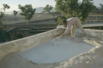 Man mending the roof of his house.