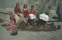 Kirghiz women making felt mats watched by children.